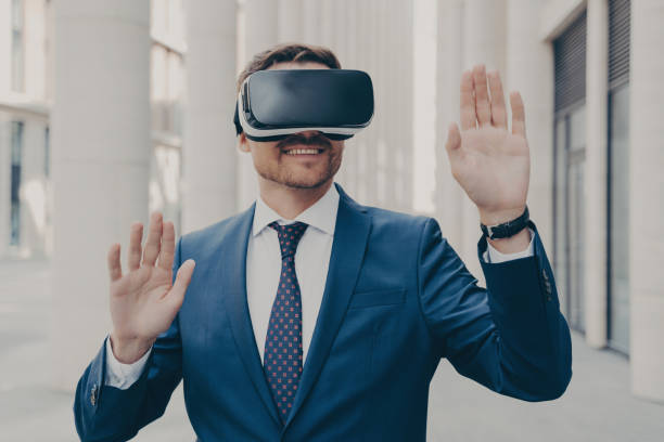 istock Smiling executive in VR headset gesturing, outdoors 1813245699