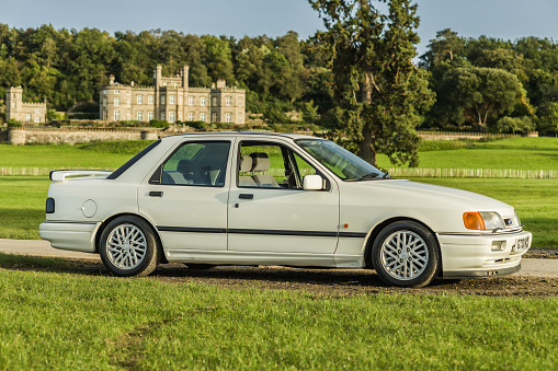 Chester, Cheshire, England, September 29th 2023. White Ford Sierra RS Cosworth Sapphire with Bolesworth Castle in the background.