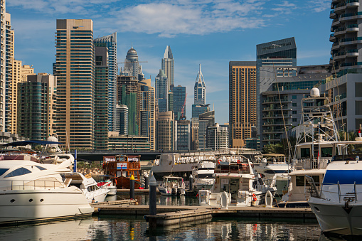 The interior parts of Dubai Marina alongside the walking strip, with views of yachts, boats, skyscrapers and hotels.