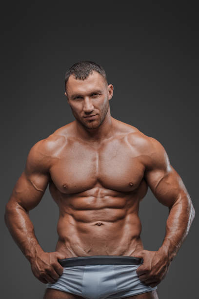Muscular Man in White Briefs on Gray Background