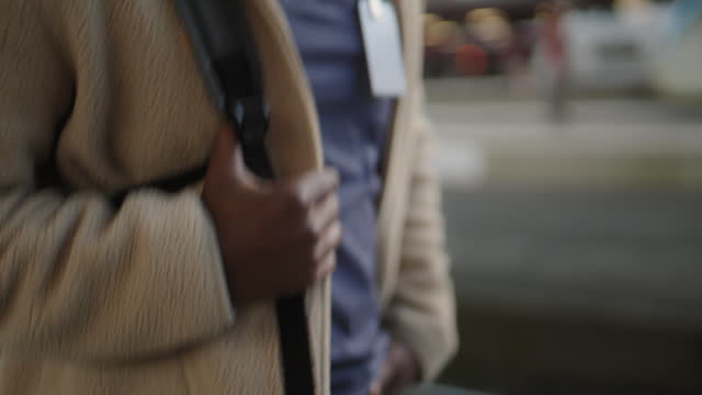 Man holding on top his backpack while walking