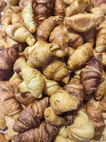 A pile of flaky, buttery croissants dusted with chocolate sprinkles