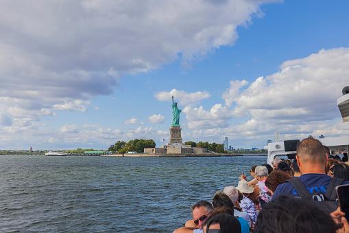 New York. USA. 09.25.2023 Boat tour on Hudson River showcasing landmarks like Statue of Liberty with tourists aboard.