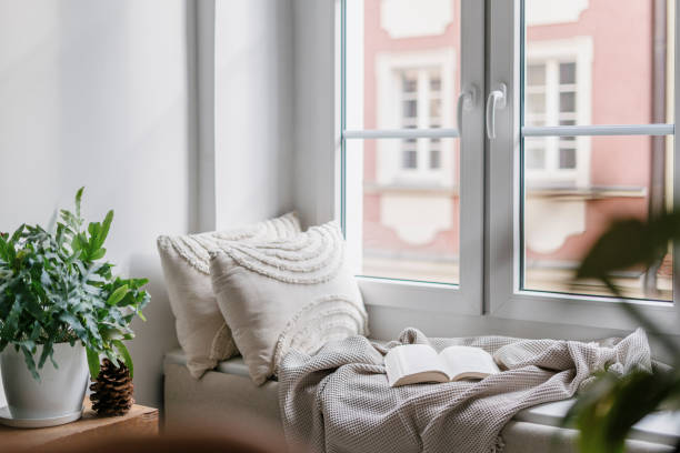 gemütliche ecke zum lesen von büchern auf der fensterbank im zimmer im nordischen stil - human settlement audio stock-fotos und bilder