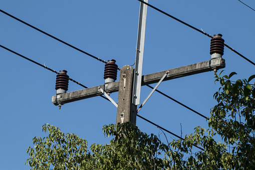 Closeup Eletricity line and electricity post wtih blue sky background