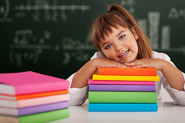 istock Happy schoolgirl leaning on her books 181327725