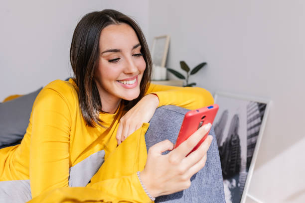 istock Happy young caucasian woman resting on sofa using cell phone. 1813319471