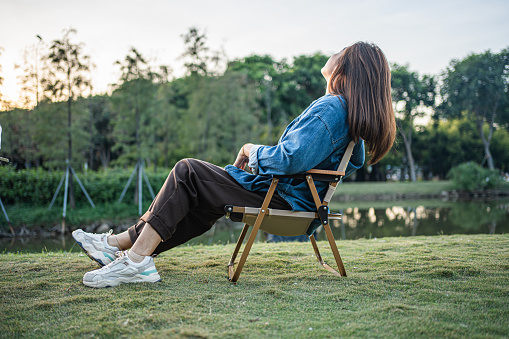 An adult female sits in a park to relax,A relaxed and free feeling