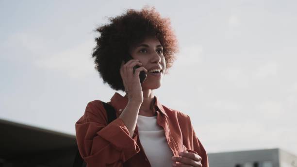 istock Smiling lady with bag talking on the smartphone outside. 1813337185