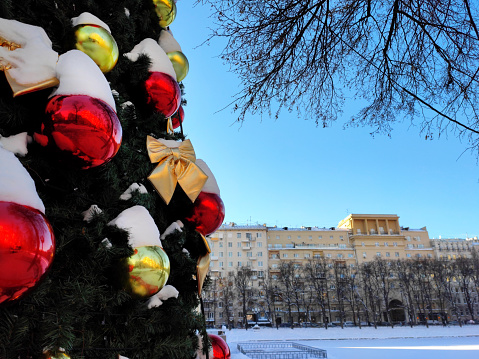 Christmas tree decorated with red and golden baubles on a sunny day in Moscow, Russia. City decorated for New Year winter holidays