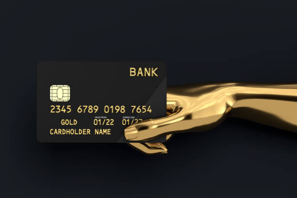 istock Black Plastic Golden Credit Card with Chip in Gold Abstract Hand. 3d Rendering 1813368439