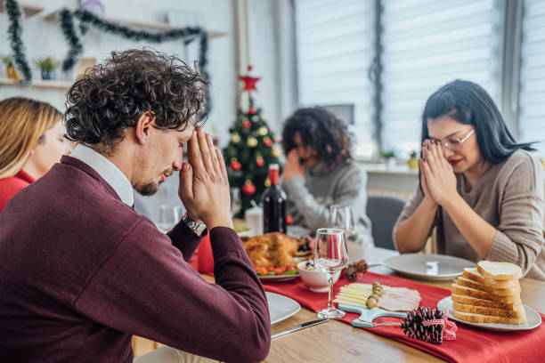 istock Man praying before eating Christmas lunch 1813371078