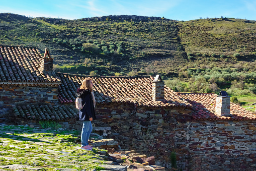 Woman enjoying the views of the old village nestled between mountains, Patones de Arriba