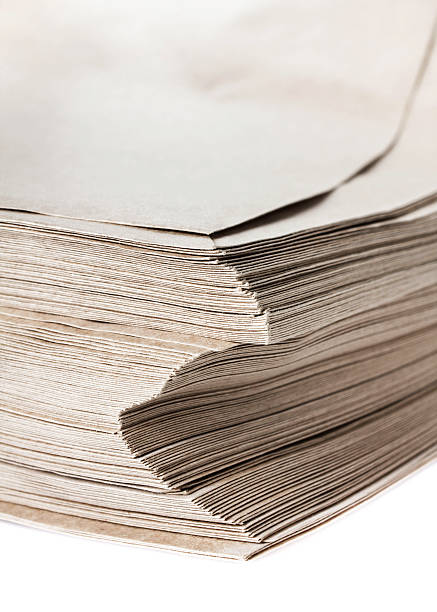istock Stack of grey recycled paper envelopes isolated on white backgro 181339210