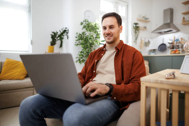 istock Young casually clothed man using laptop at home 1813443616
