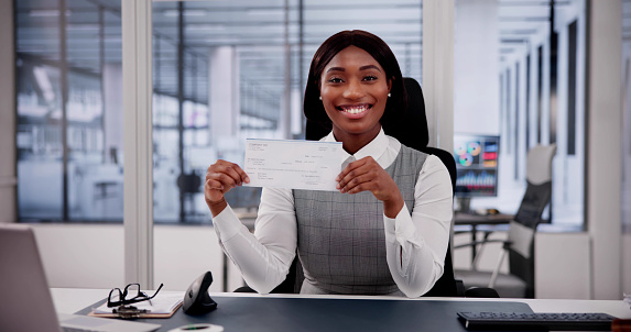 Business Woman Holds Checkbook, Examining Paycheck and Cheque