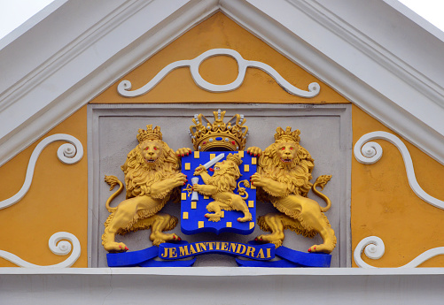Willemstad, Curaçao, Kingdom of the Netherlands: Willemstad city hall, completed in 1858, neoclassical building designed by First Lieutenant Engineer W. Schut - pediment with the coat of arms of the Kingdom of the Netherlands - chequered shield with a lion holding a sword and arrows, held by two lions, topped with a crown- The Netherlands' motto, 'Je Maintiendrai' ('I will maintain'), is taken from the coat of arms of the family of Orange-Nassau - Wilhelminaplein. Raadhuis Willemstad.
