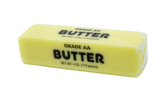 Ocala, Florida - November 2, 2023 block or stick of AA grade Traditional wrapped butter isolated on white background 4 ounces or 113 grams. Front top side horizontal angle view with crimped edges