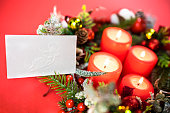 Catholic Christmas wafer, bread, plate next to 4 Advent candles and a wreath. wafer - a thin sheet of baked unleavened dough, like a wafer. Made in the form of a sheet of  rectangular shape