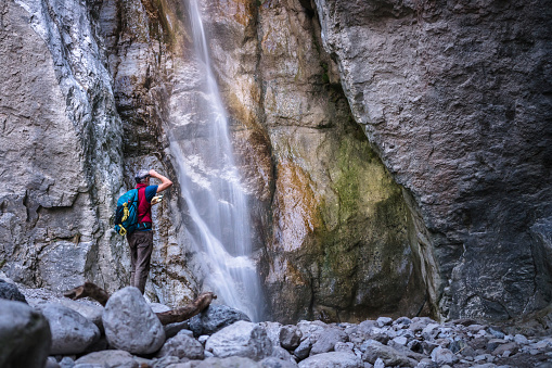 hiker exploring  waterfall in the canyon