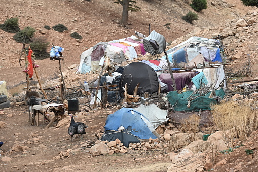 Atlas Mountains, October 2023: Nomadic settlement. The simple huts and tents are made of blankets and plastic sheets. Difficult living conditions in a barren landscape.