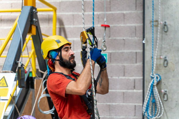 istock Climber wearing his helmet checks the rope before climbing 1813508029