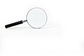 A photo featuring a magnifying glass with a black handle and a silver rim around the magnifying glass, captured against a white background.