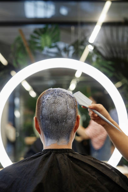 rückansicht des kunden im schönheitssalon, der buzzcut-haare blondiert - lightener stock-fotos und bilder