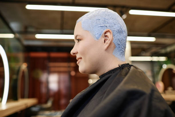 mujer joven sonriente con cabello decolorado con corte de pelo en salón de belleza - lightener fotografías e imágenes de stock