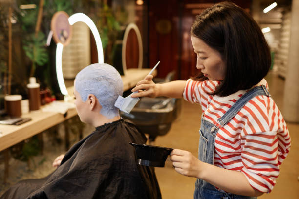 peluquero que aplica decolorante al cabello corto con corte de pelo en un salón de belleza - lightener fotografías e imágenes de stock