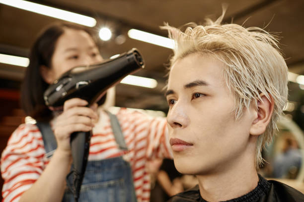 primer plano joven asiático en salón de belleza con peluquero secando el cabello - lightener fotografías e imágenes de stock