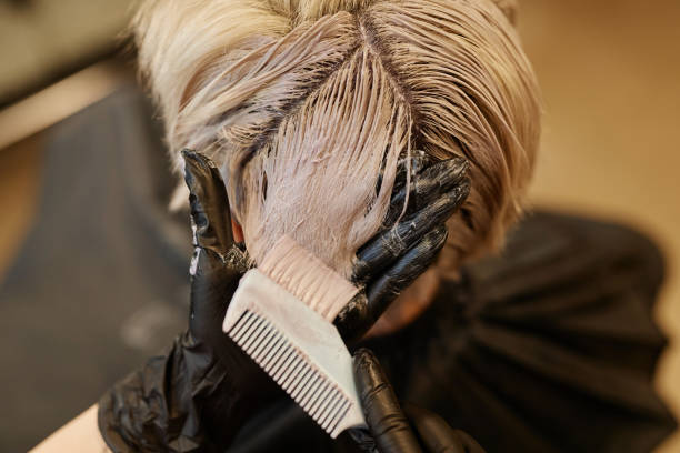 미용실에서 머리카락에 표백제 또는 염료를 바르는 헤어 스타일리스트의 클로즈업 - lightener 뉴스 사진 이미지