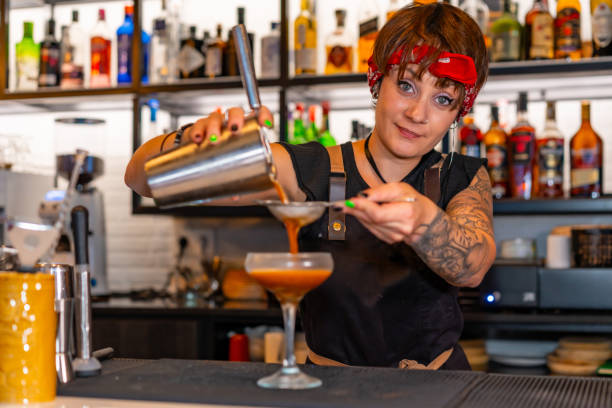 istock Happy bartender pouring cocktail into a cocktail glass 1813578527