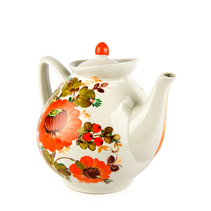 Vintage porcelain teapot with floral pattern isolated on white background.