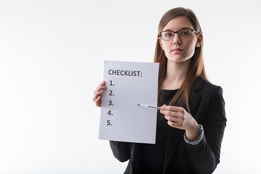 professional woman presents a checklist, symbolizing organization, planning, and the step-by-step achievement of goals