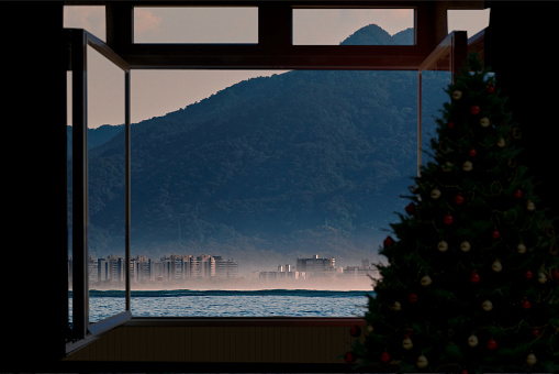 Photomontage with the silhouette of a Christmas tree next to a window, with a view of the Brazilian coast in the background, conceptualizing Christmas festivities in the tropics - BERTIOGA,  SAO PAULO,  BRAZIL