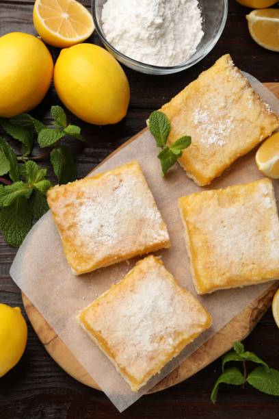 istock Tasty lemon bars with powdered sugar and mint on wooden table, flat lay 1813638271