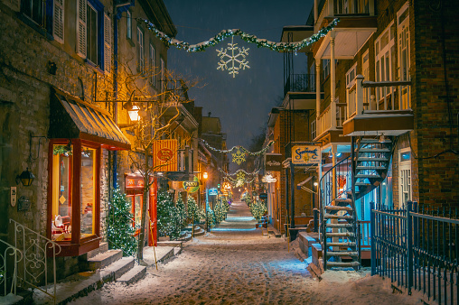 Shops on the historical Petit-Champlain Street with Christmas winter holidays decorations on a snowy night, oldest commercial street in North America, lower town of Old Quebec, Quebec City, Canada