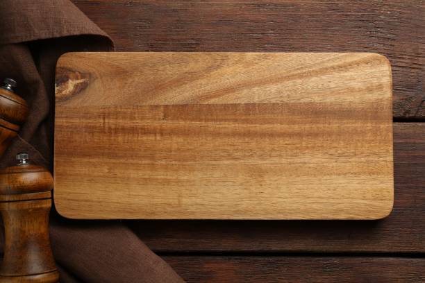 istock New cutting board and shakers on wooden table, flat lay 1813639373