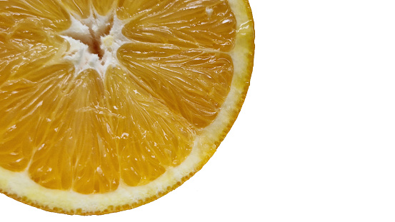 Cross section of a fresh ripe orange next to a freshly squeezed glass of orange juice.