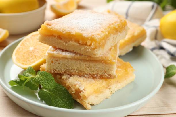 istock Tasty lemon bars with powdered sugar and mint on table, closeup 1813644296