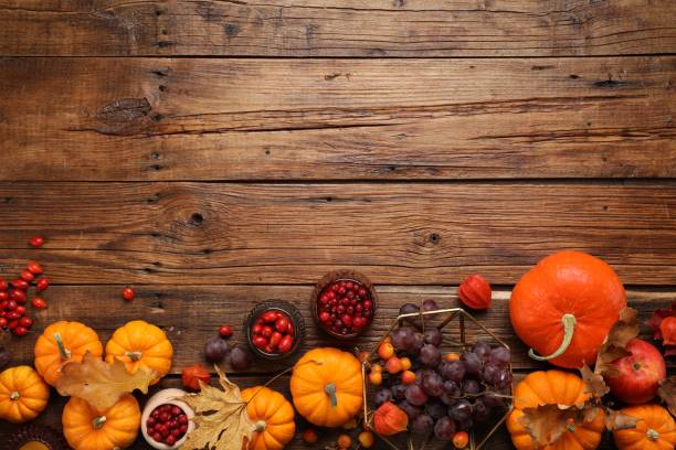 istock Flat lay composition with autumn leaves, berries and pumpkins on wooden table, space for text 1813651292