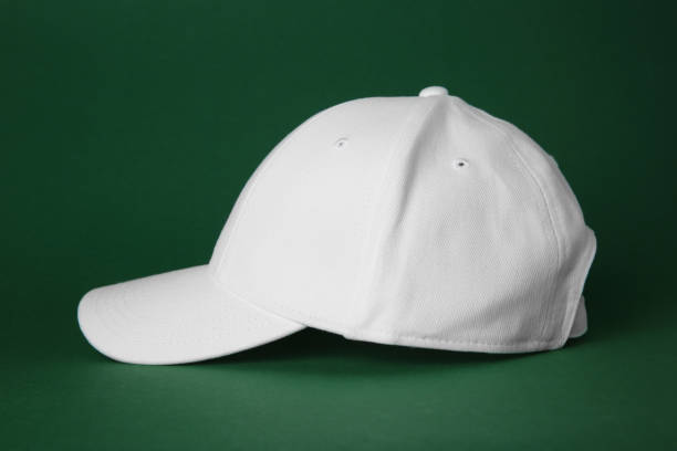istock Stylish white baseball cap on dark green background 1813652377