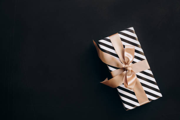 istock Christmas New Year background present box and festive decorations on black background 1813667300