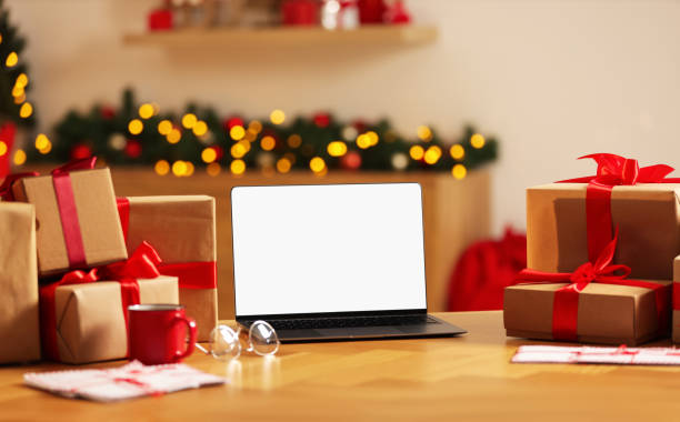 istock Christmas time. Laptop with blank screen, gift boxes and letters on table at home 1813685669