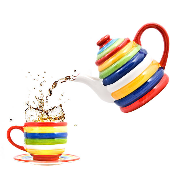 istock color teapot with cup and splash of tea isolated 181369046