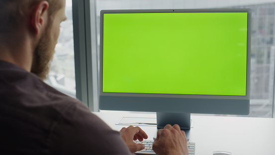 Programmer typing chromakey keyboard at office. Developer coding green screen pc