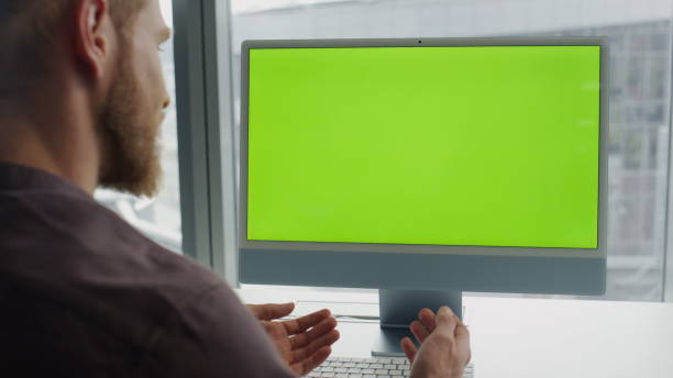 istock Gesturing freelancer virtual call chromakey monitor office. Man using mockup pc 1813726330