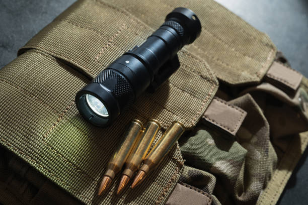 istock Tactical weapon flashlight and 5.56x45mm cartridges. 1813733584