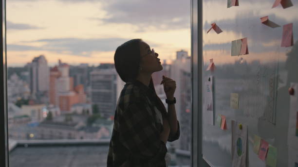istock Girl silhouette examining sticker at sunset close up. Lady brainstorming alone 1813749607